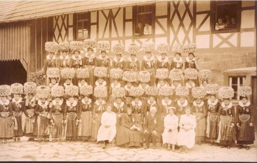   Ansichtskarte AK Trachtenverein viele Frauen mit imposantem Kopfschmuck vor Fachwerkhaus 