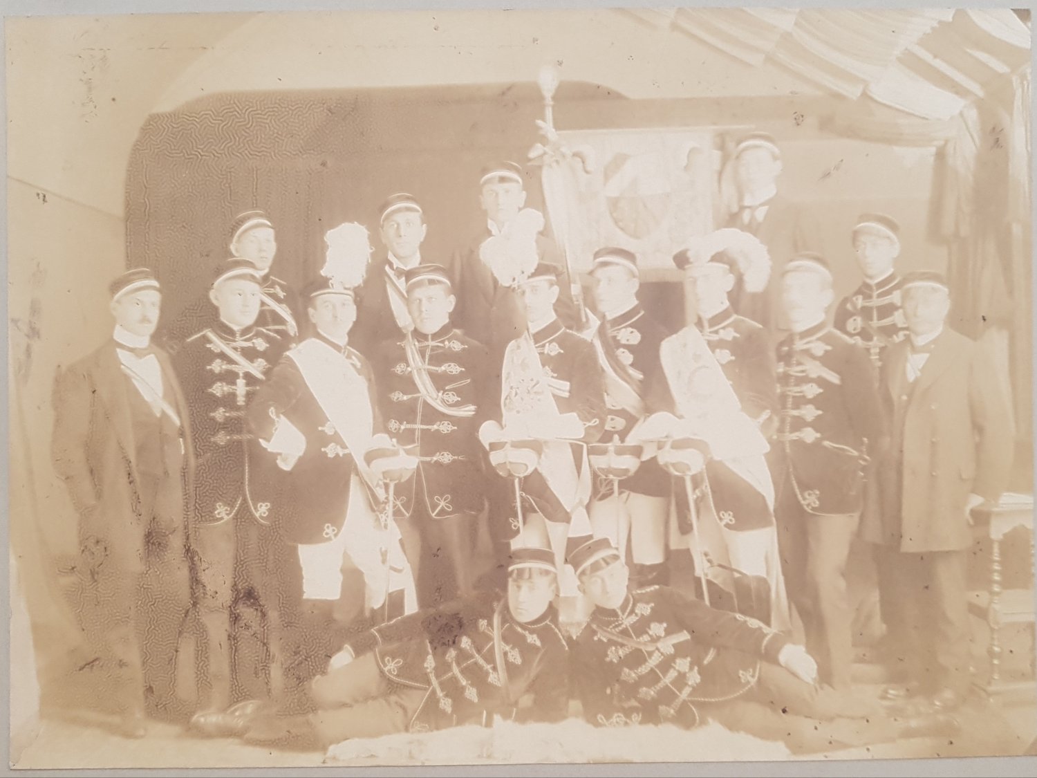   Original-Photographie einer Studentenverbindung um 1900. (Ansicht: Verbindungsgruppe im Traditionszimmer vor Verbindungswappen). 