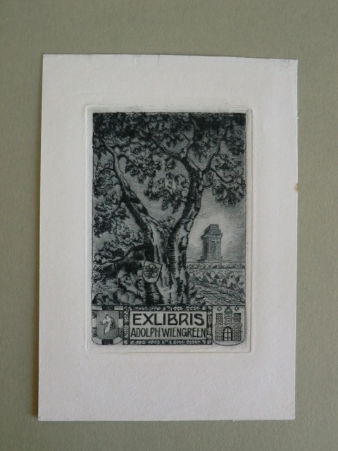 Häffcke, Friedrich:  Exlibris für Adolph Wiengreen. Motiv: Baum mit Wappen. Im Hintergund eine Art Monument. Unten links und rechts zwei weitere Wappen 