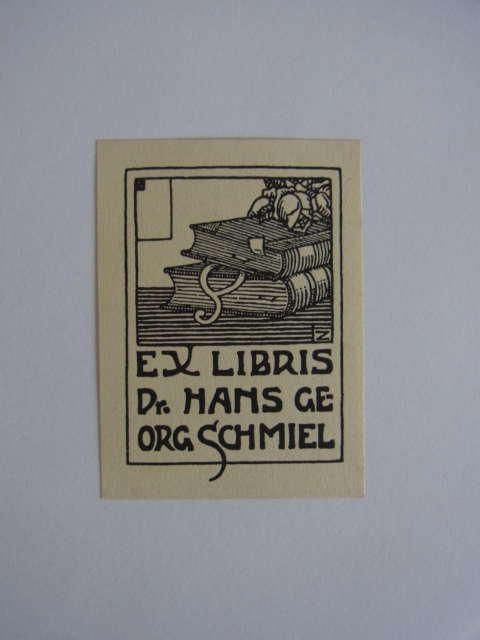 Unbekannter Künstler, monogrammiert mit Z:  Exlibris für Dr. Hans Georg Schmiel. Motiv: Zwei Bücher, auf denen eine Rose liegt, zwischen den Büchern lugt ein Paragraphen-Zeichen heraus 